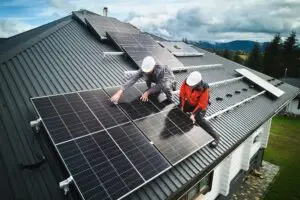 Technicien ECOTECH installant un panneau solaire à Biscarrosse
